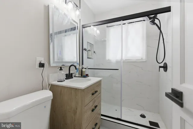 a bathroom with a granite countertop sink a mirror a vanity and a shower