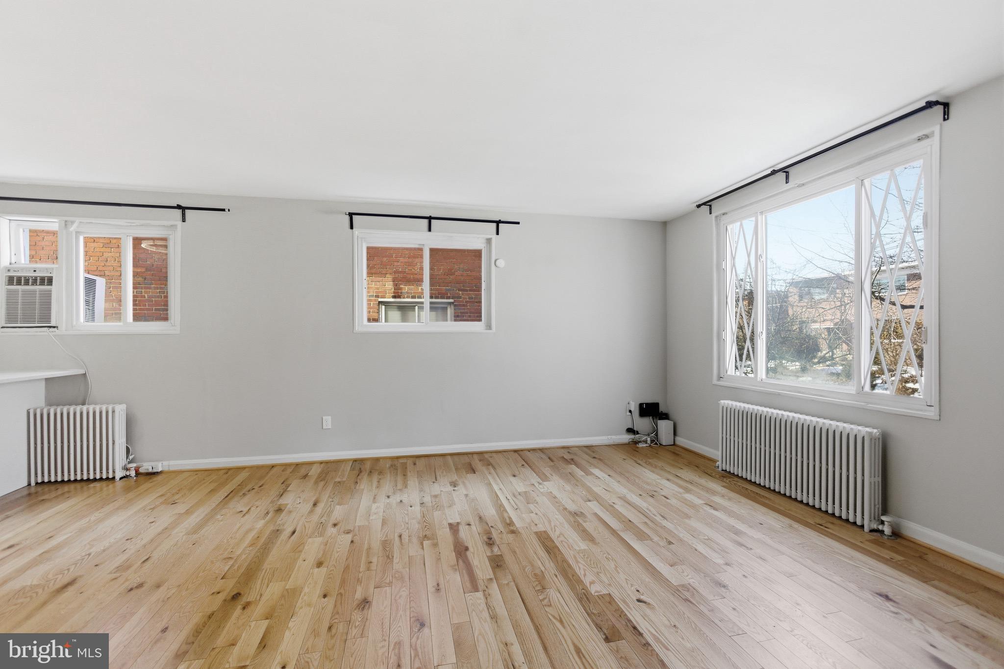 7519 8th Street Northwest Washington, DC 20012 - Photo 3 of 19 a view of an empty room with wooden floor and a window