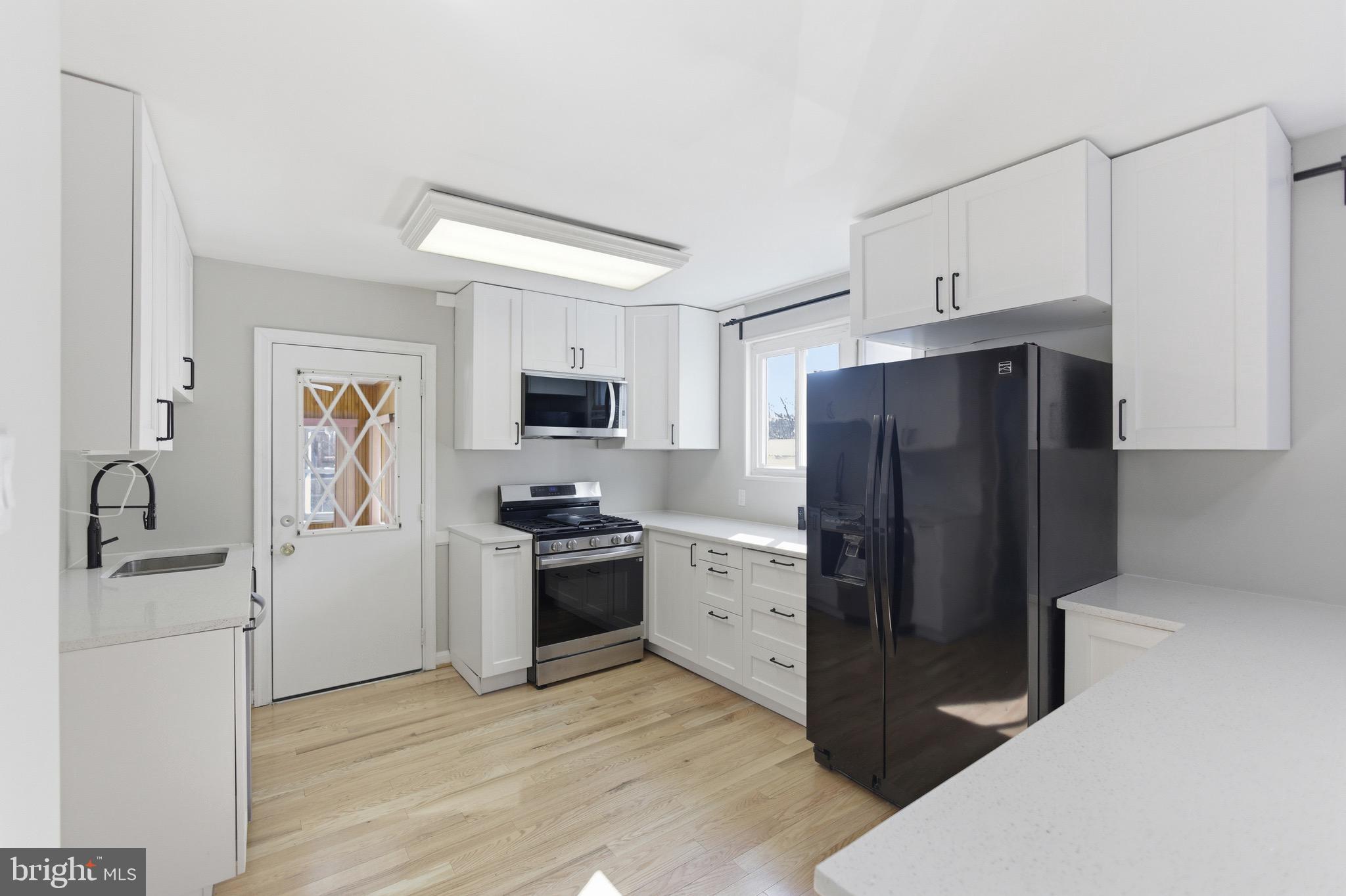 7519 8th Street Northwest Washington, DC 20012 - Photo 5 of 19 a kitchen with granite countertop a refrigerator stove and sink