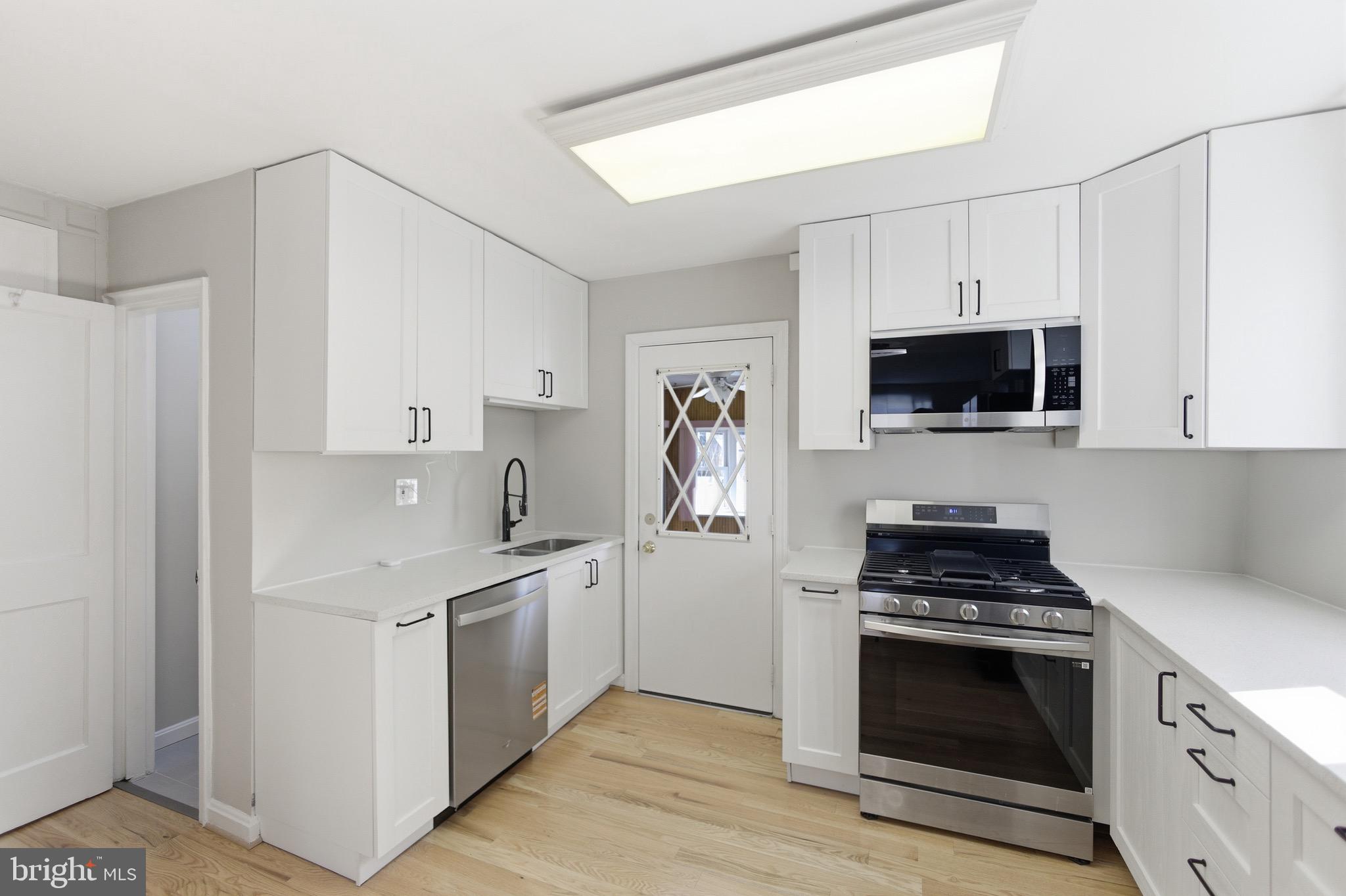 7519 8th Street Northwest Washington, DC 20012 - Photo 6 of 19 a kitchen with stainless steel appliances a white stove top oven and cabinets