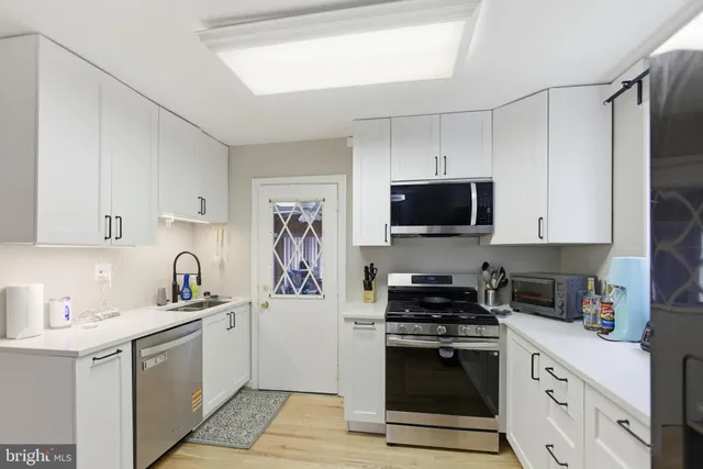a kitchen with stainless steel appliances a stove sink microwave and cabinets