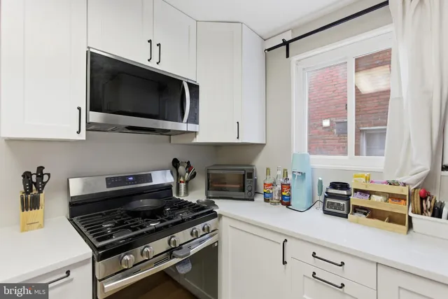 a kitchen with stainless steel appliances a stove a microwave and cabinets