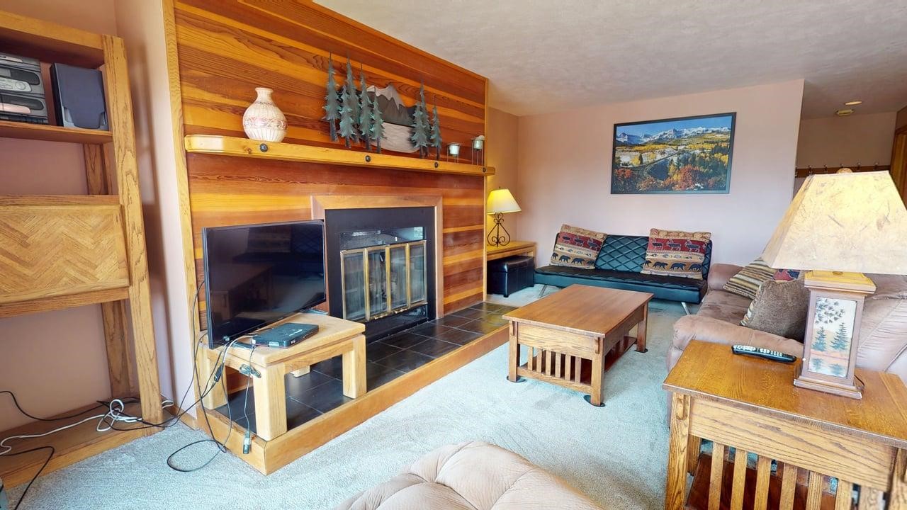 91200 Ryan Gulch Road, Unit 213 Silverthorne, CO 80498 - Photo 6 of 33 a living room with furniture and a fireplace