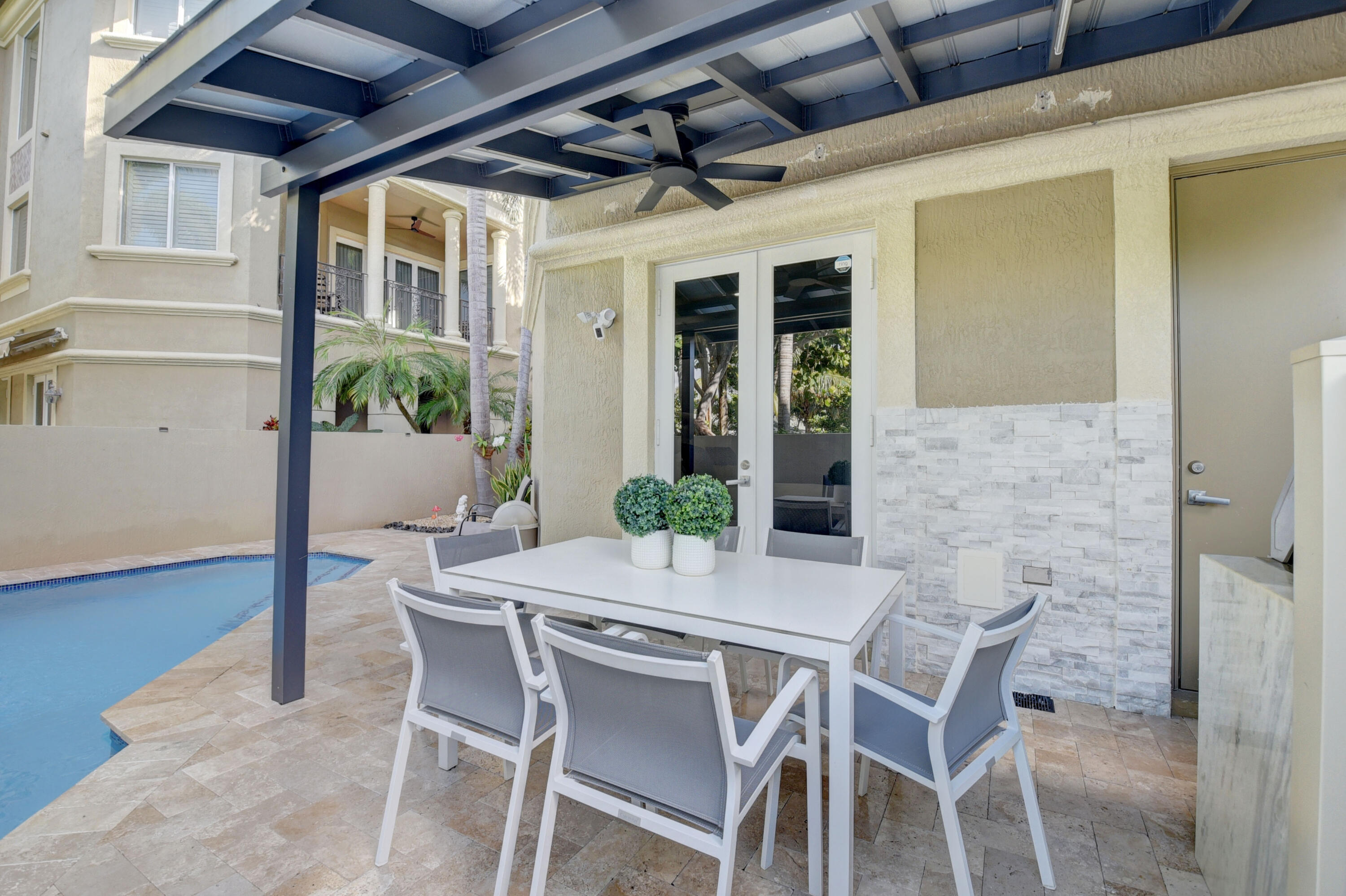 921 Osceola Drive, Unit 4 Boca Raton, FL 33432 - Photo 9 of 46 a view of an outside dining space with a table and chairs