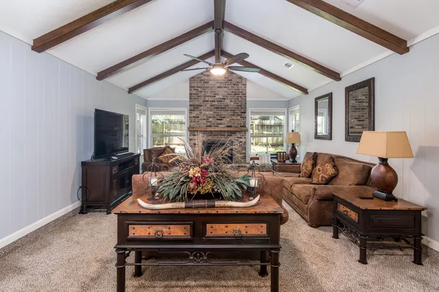 a living room with furniture a chandelier and a flat screen tv