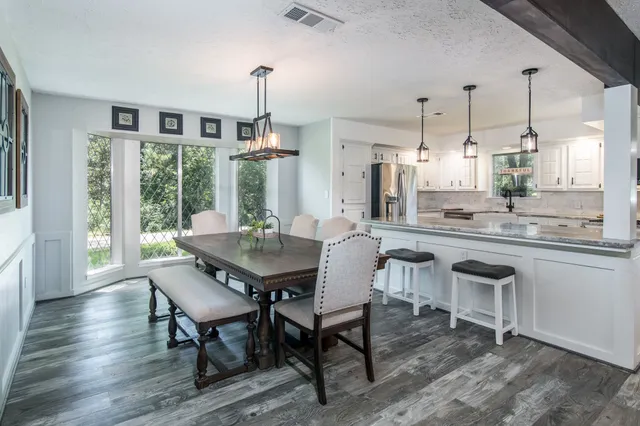 a dining room with furniture a chandelier and wooden floor
