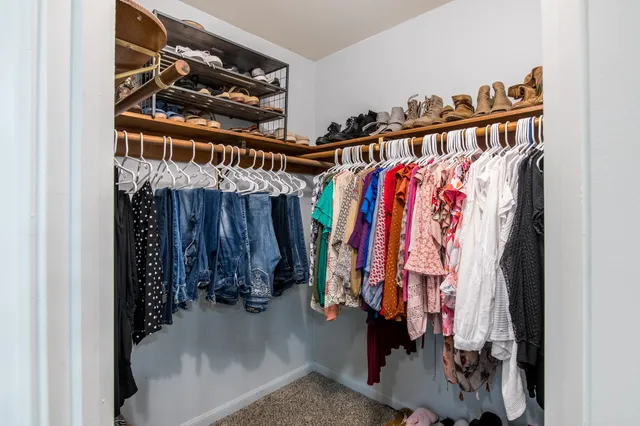 a view of walk in closet with clothes and shoes