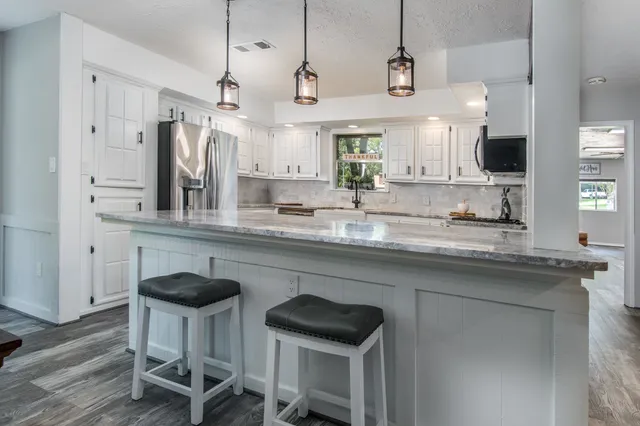 a kitchen with stainless steel appliances granite countertop a sink and a refrigerator