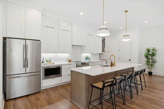 a kitchen with granite countertop a sink a counter space appliances and cabinets