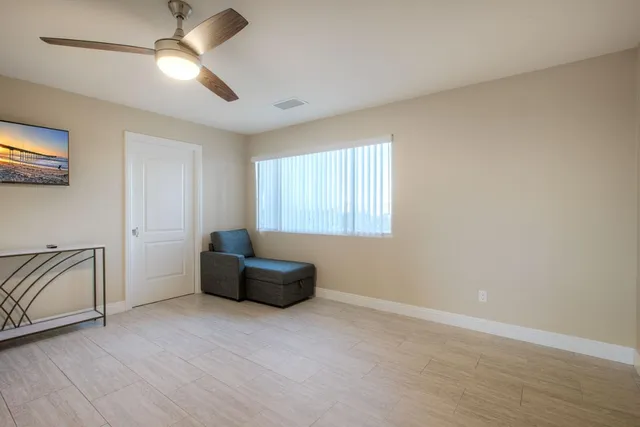 an empty room with windows and fan