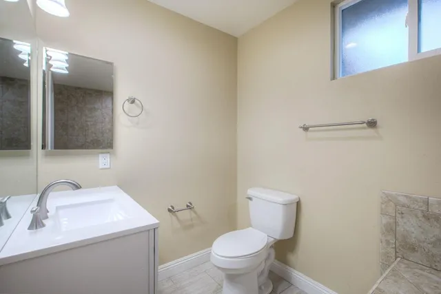 a bathroom with a toilet sink and mirror