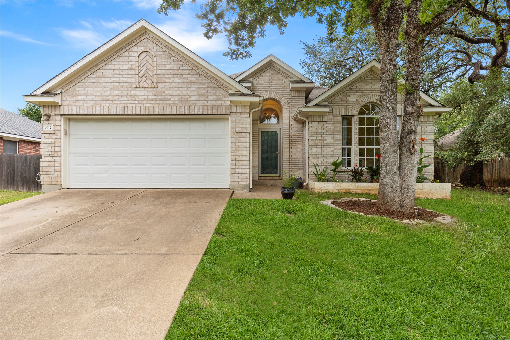 9012 Meacham Way Austin, TX 78749 - Photo 1 of 34 Light brick exterior with an arched entryway and a prominent front-facing garage