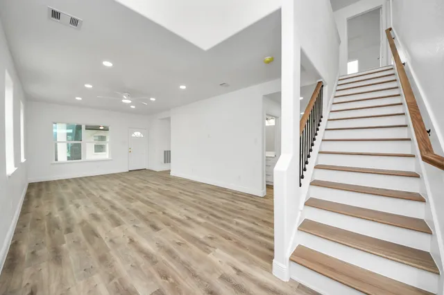 a view of empty room with wooden floor and windows