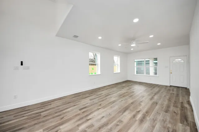a view of empty room with wooden floor