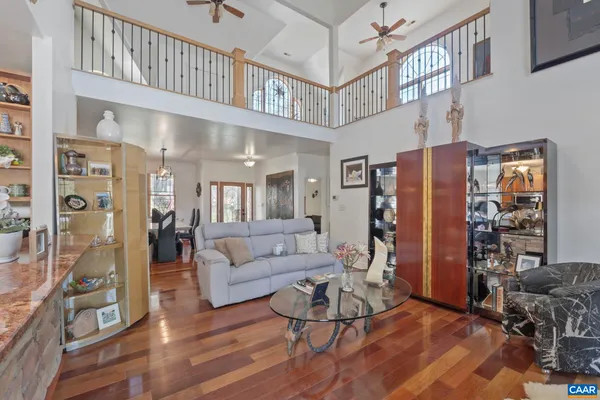 a living room with furniture a ceiling fan a rug and a window