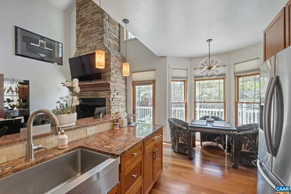 a kitchen with kitchen island granite countertop a sink dining table and chairs
