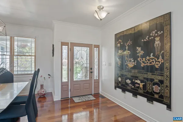 a view of a dining room with furniture a chandelier and wooden floor