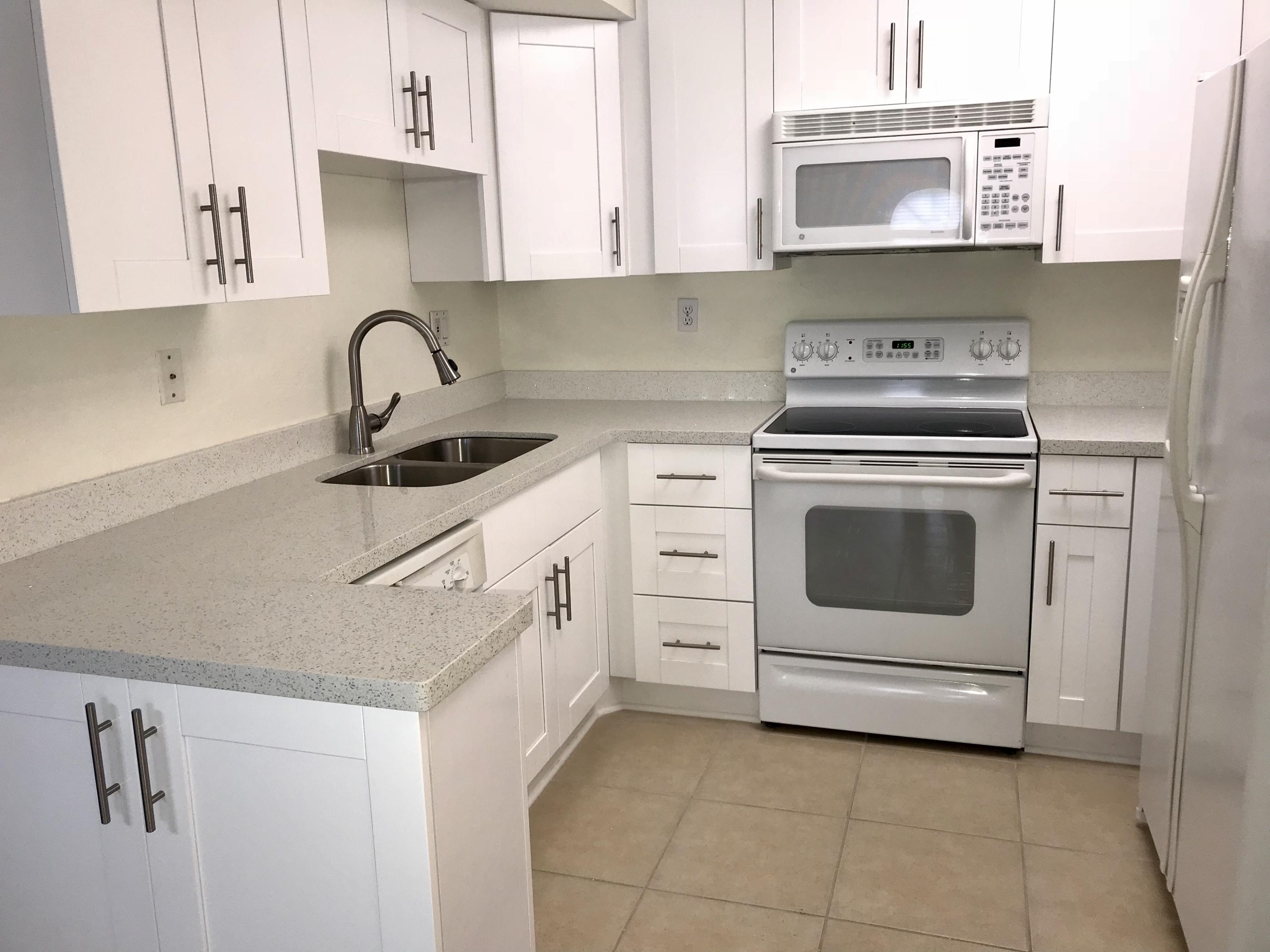 8249 Thames Boulevard, Unit B Boca Raton, FL 33433 - Photo 2 of 46 a kitchen with cabinets appliances and a sink