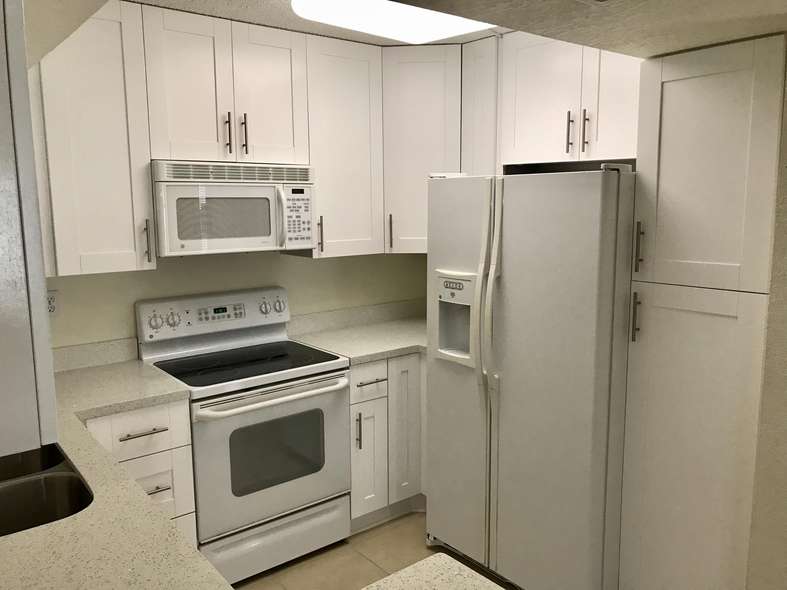 8249 Thames Boulevard, Unit B Boca Raton, FL 33433 - Photo 3 of 46 a kitchen with a stove microwave and refrigerator