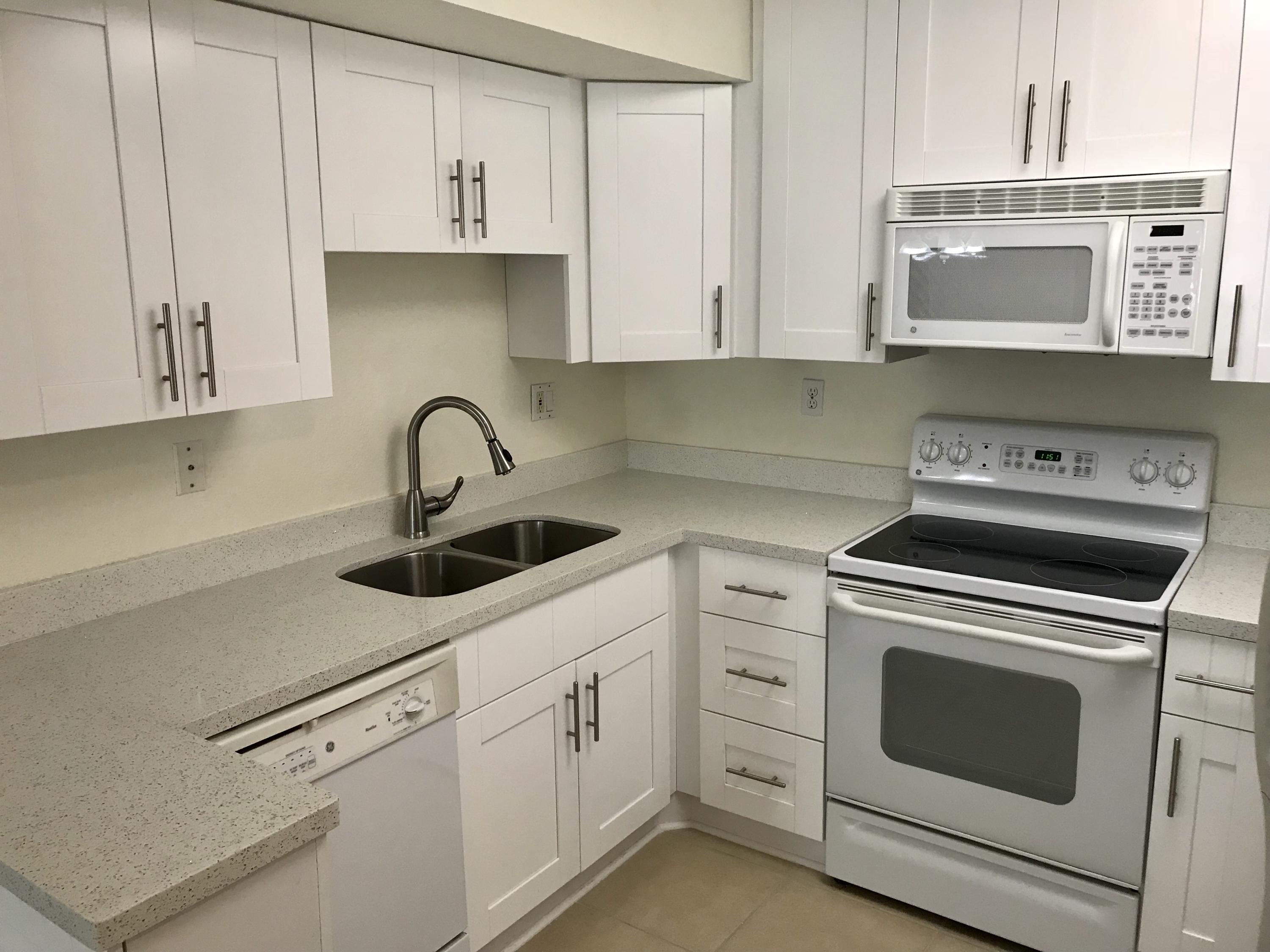8249 Thames Boulevard, Unit B Boca Raton, FL 33433 - Photo 4 of 46 a kitchen with cabinets appliances a sink and a counter top