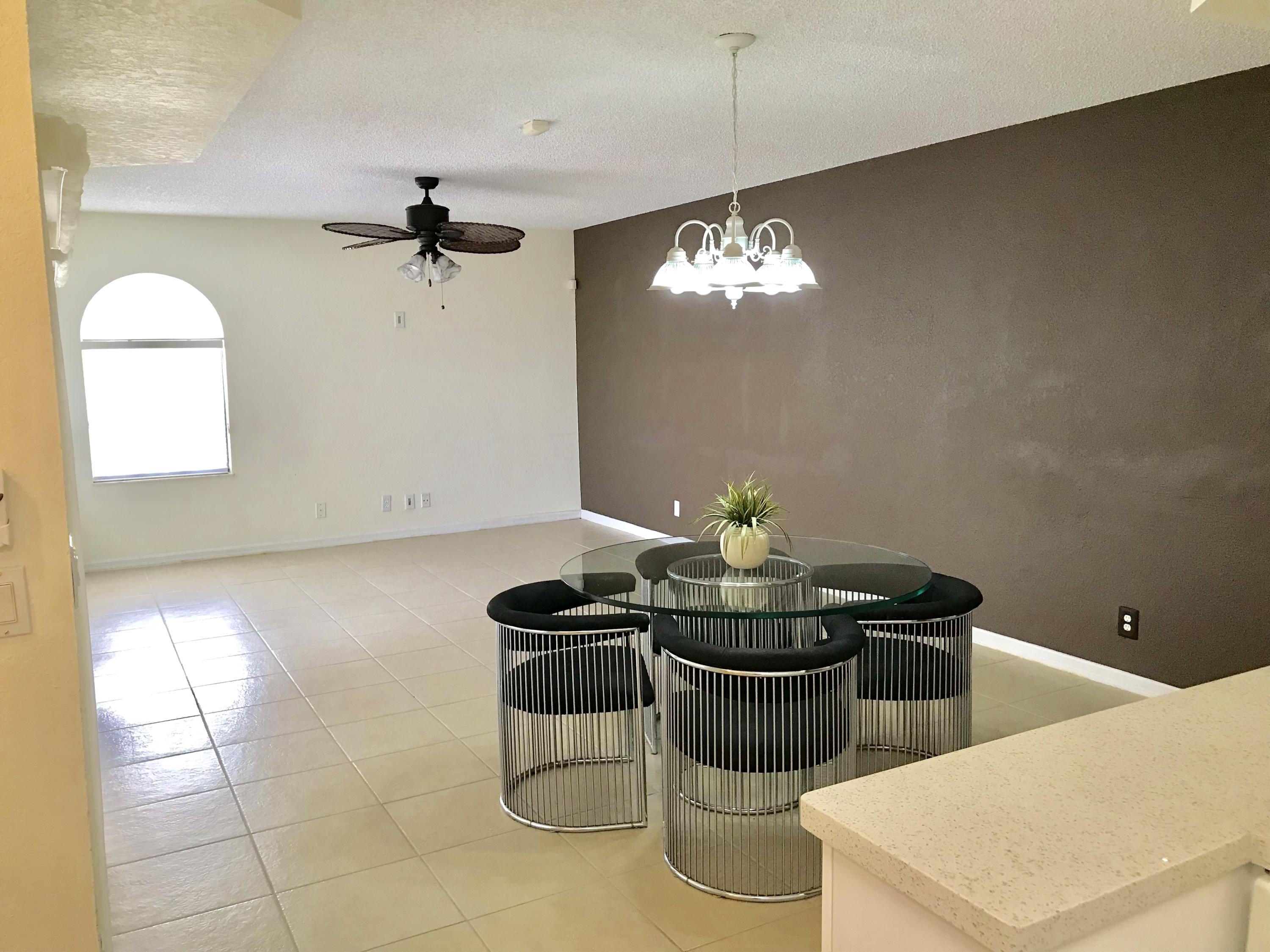 8249 Thames Boulevard, Unit B Boca Raton, FL 33433 - Photo 10 of 46 a kitchen with a appliances dining table and chairs
