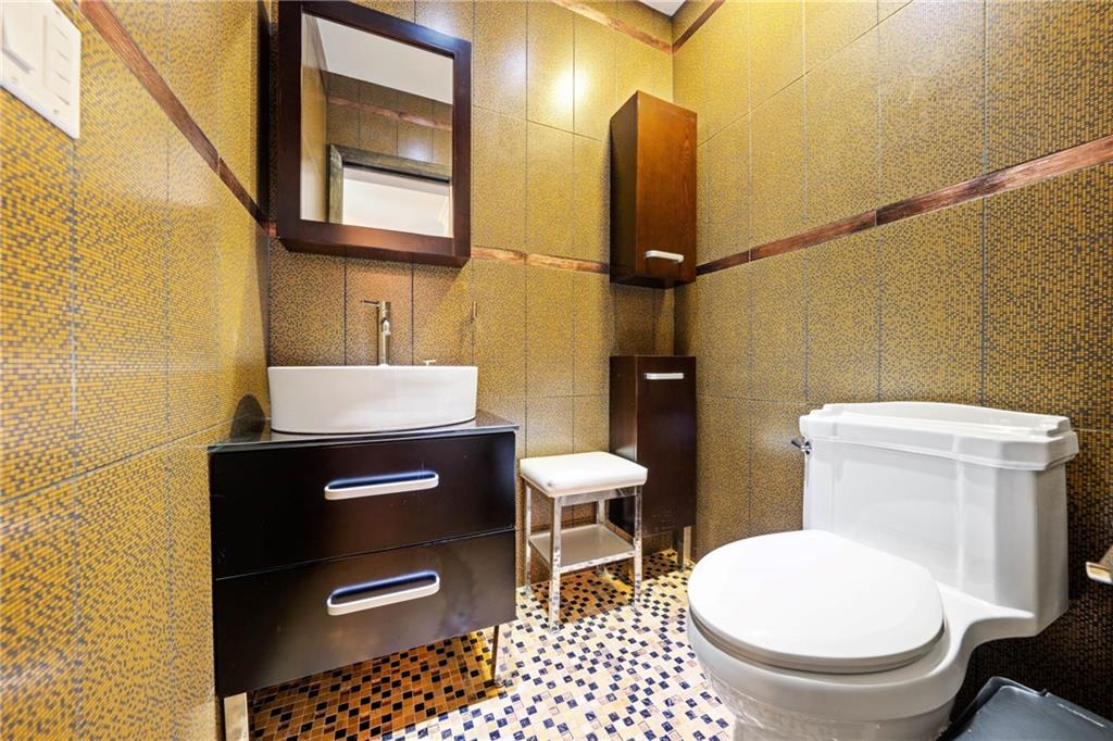 2615 Avenue O, Unit 6C Brooklyn, NY 11210 - Photo 6 of 10 a bathroom with a toilet a sink and mirror