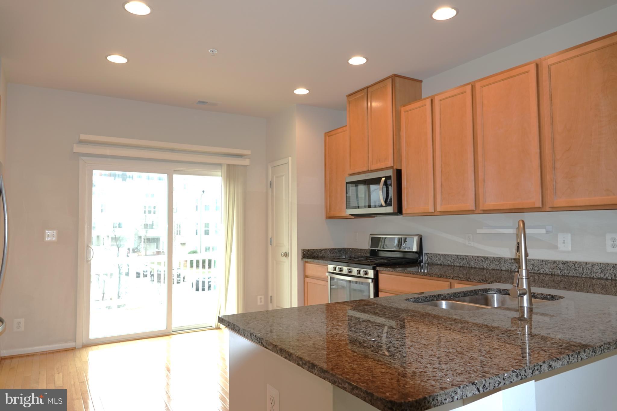 110 Strummer Lane Gaithersburg, MD 20878 - Photo 4 of 22 a kitchen with stainless steel appliances granite countertop a sink a stove and a microwave
