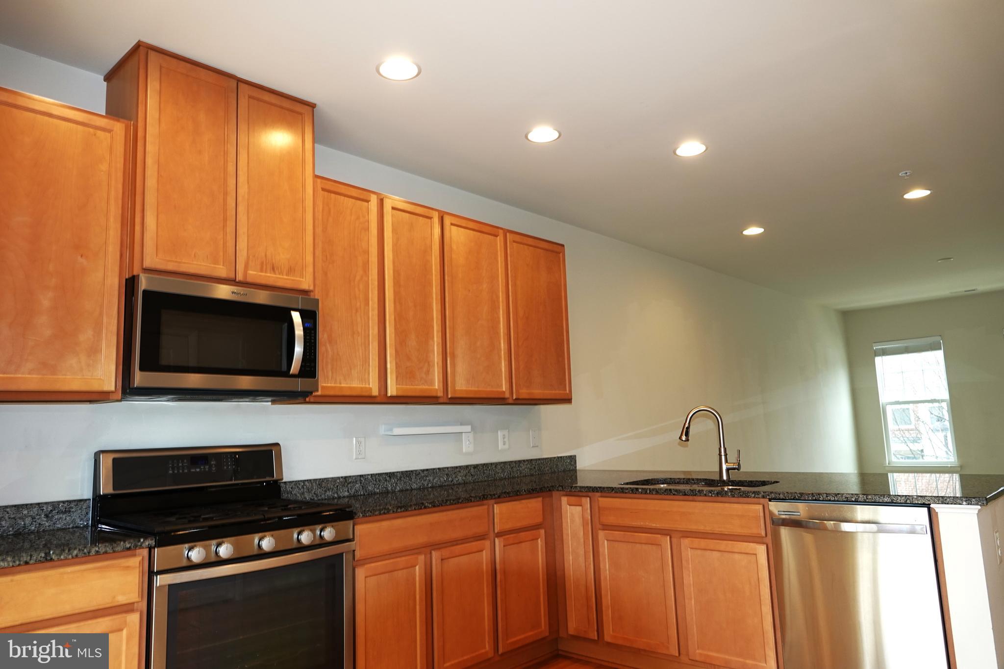 110 Strummer Lane Gaithersburg, MD 20878 - Photo 6 of 22 a kitchen with granite countertop a stove and a sink