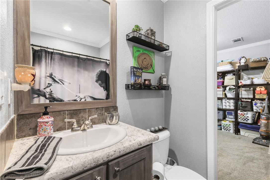 735 Boysenberry Road Somerville, TX 77879 - Photo 13 of 27 a bathroom with a granite countertop sink a toilet and mirror