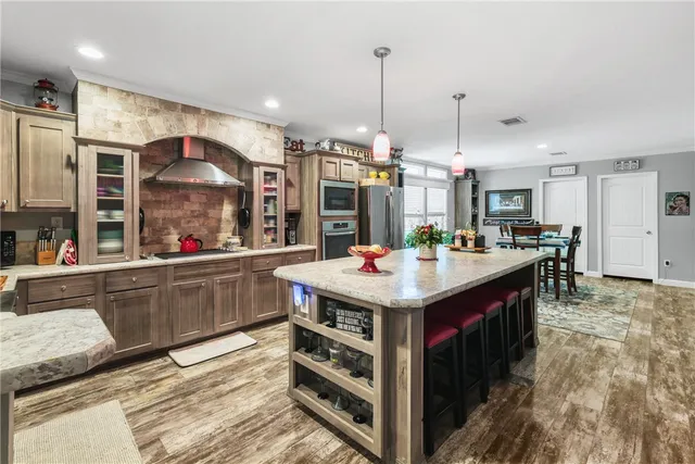 a kitchen with kitchen island granite countertop a sink and a stove
