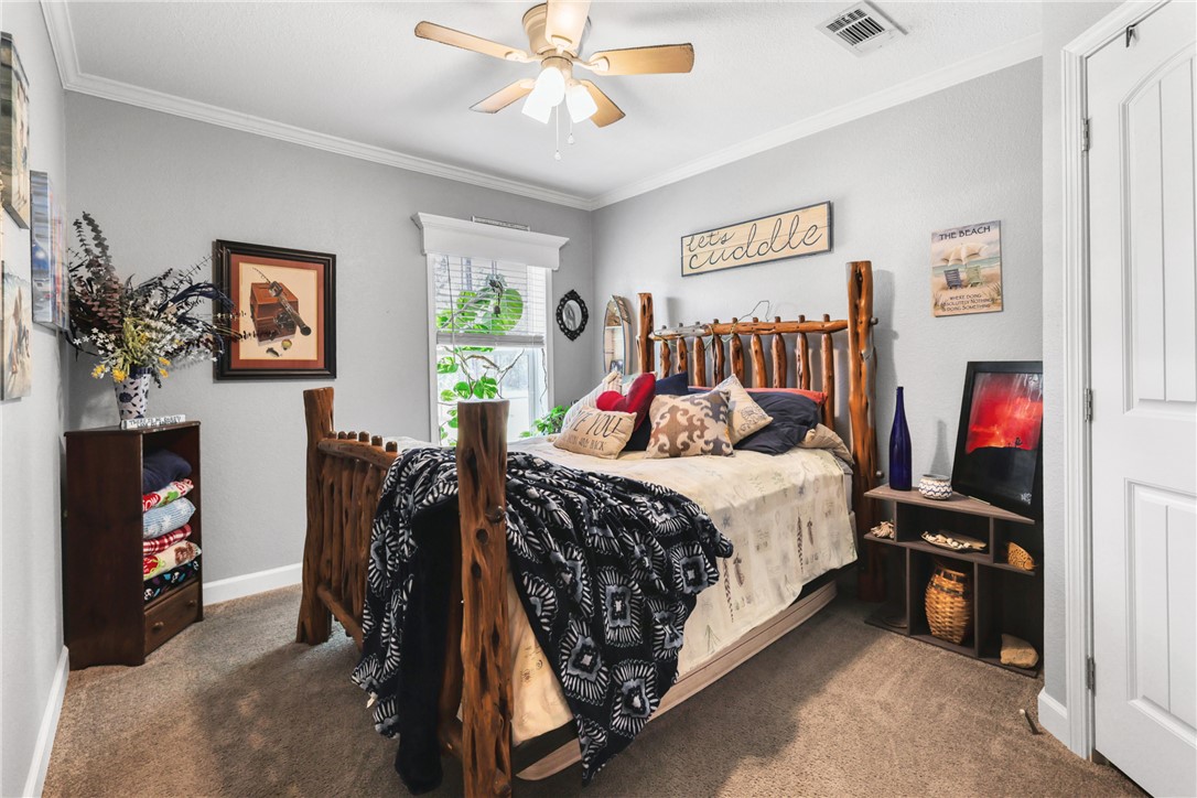 735 Boysenberry Road Somerville, TX 77879 - Photo 7 of 27 a bedroom with a bed and a chandelier
