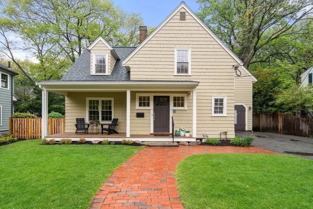 a front view of a house with a yard and chairs