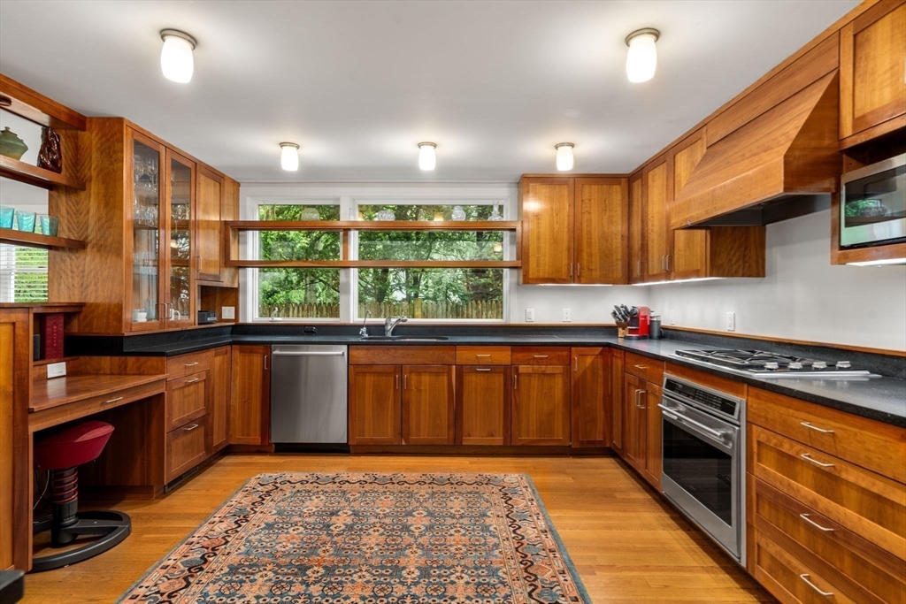 33 Manchester Road Newton, MA 02461 - Photo 12 of 31 a kitchen with stainless steel appliances granite countertop a stove a sink and a microwave