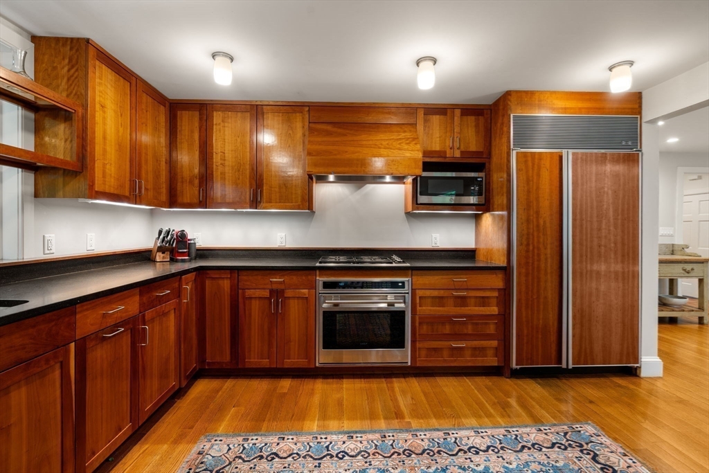 33 Manchester Road Newton, MA 02461 - Photo 13 of 31 a kitchen with stainless steel appliances granite countertop a stove a sink and a microwave
