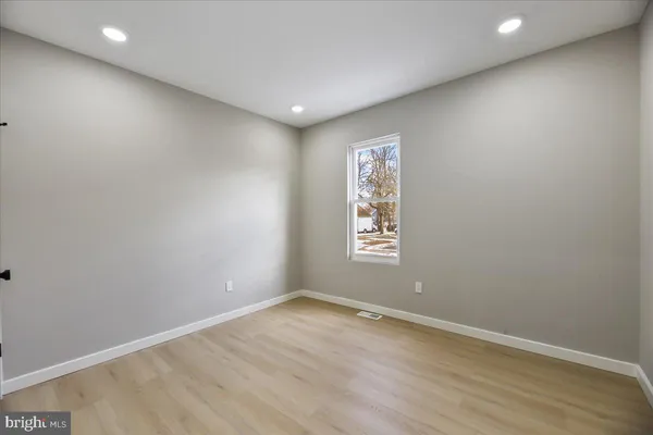 an empty room with wooden floor and window