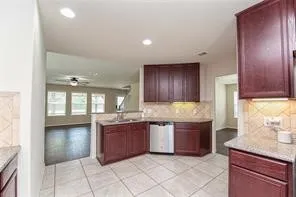 a large kitchen with granite countertop a sink and cabinets