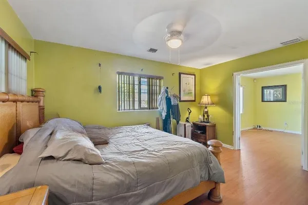 a bedroom with a bed and wooden floor