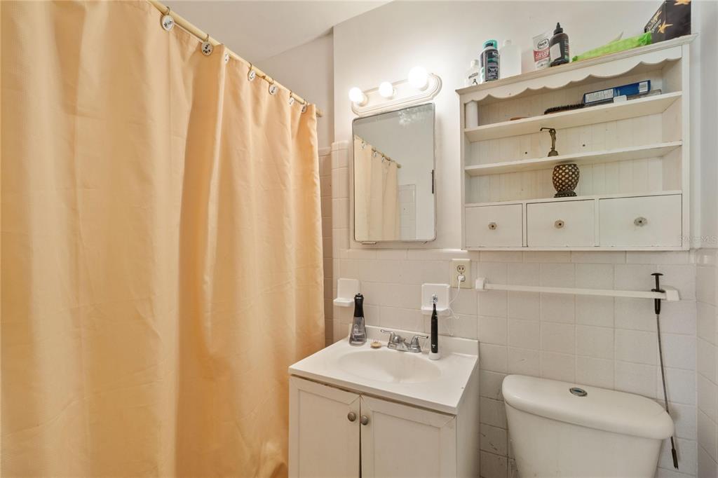 820 3rd Avenue Southwest Largo, FL 33770 - Photo 17 of 25 a bathroom with a sink a toilet and shower curtain