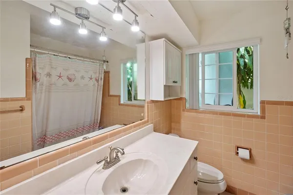 a bathroom with a sink a toilet and shower