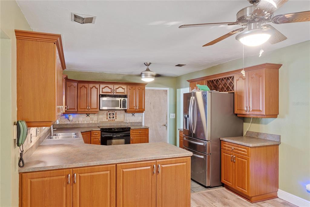 820 3rd Avenue Southwest Largo, FL 33770 - Photo 7 of 25 a kitchen with stainless steel appliances granite countertop a sink stove and refrigerator
