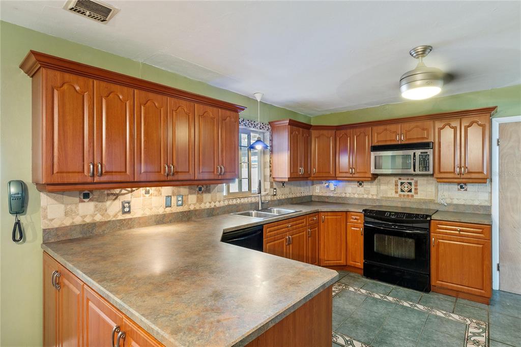 820 3rd Avenue Southwest Largo, FL 33770 - Photo 8 of 25 a kitchen with stainless steel appliances granite countertop a sink stove and refrigerator