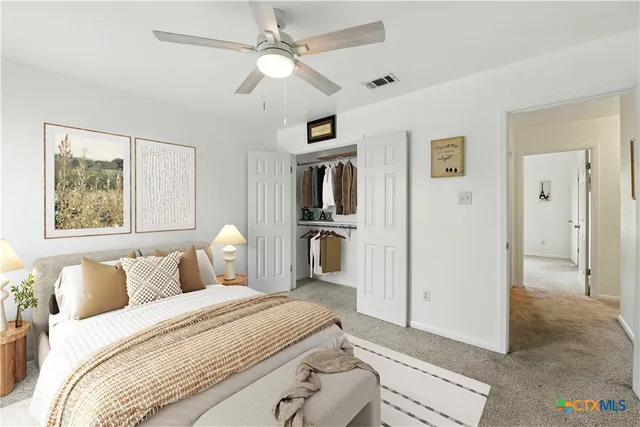 an empty room with windows and a ceiling fan