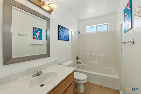 a bathroom with a sink a mirror a bathtub and a toilet