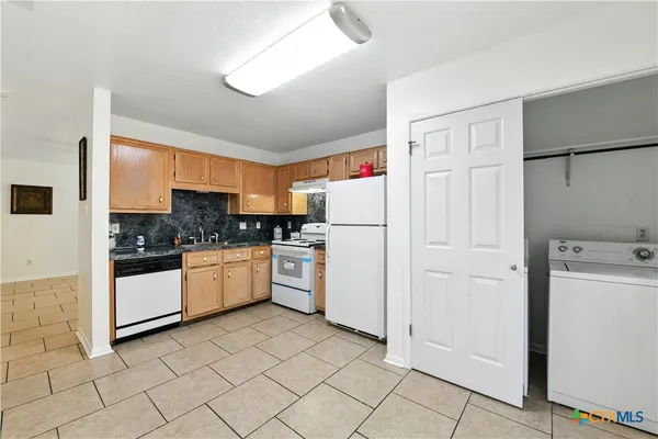 a kitchen with white cabinets and white appliances