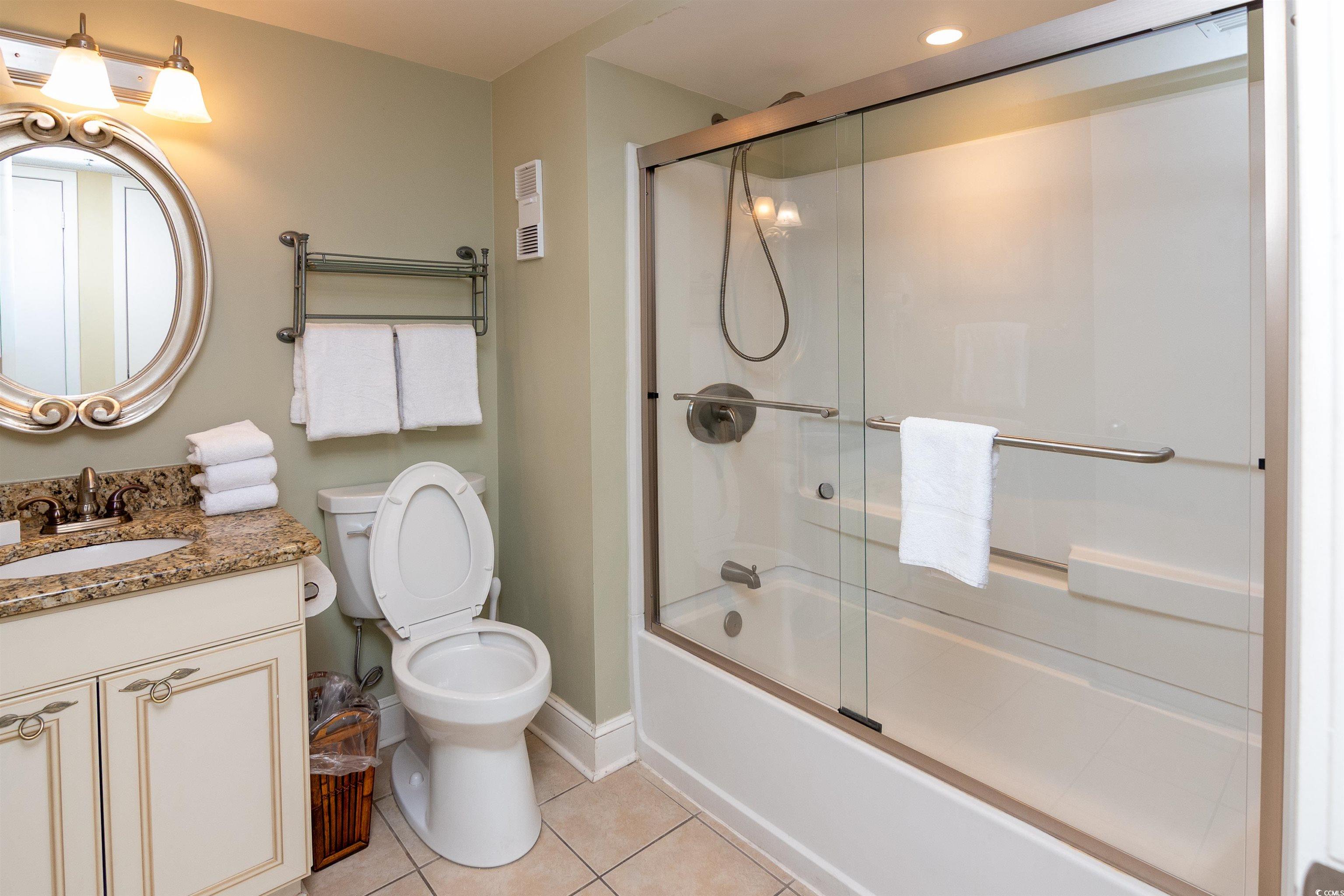 9820 Queensway Boulevard, Unit 1006 Myrtle Beach, SC 29572 - Photo 21 of 30 Full bath with vanity, shower / bath combination with glass door, and light tile patterned floors