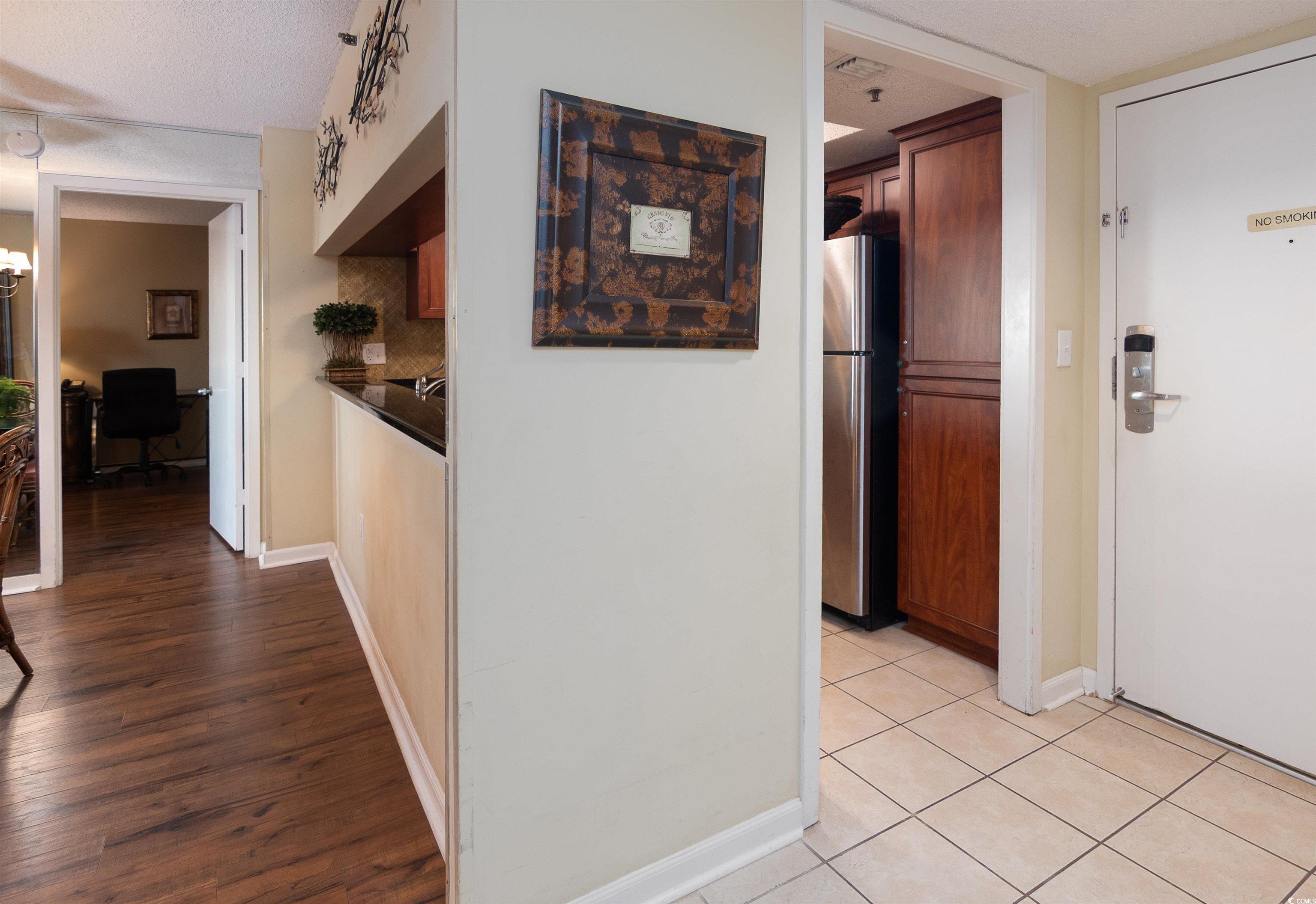 9820 Queensway Boulevard, Unit 1006 Myrtle Beach, SC 29572 - Photo 5 of 30 Hall with an office area, a textured ceiling, and dark tile patterned flooring