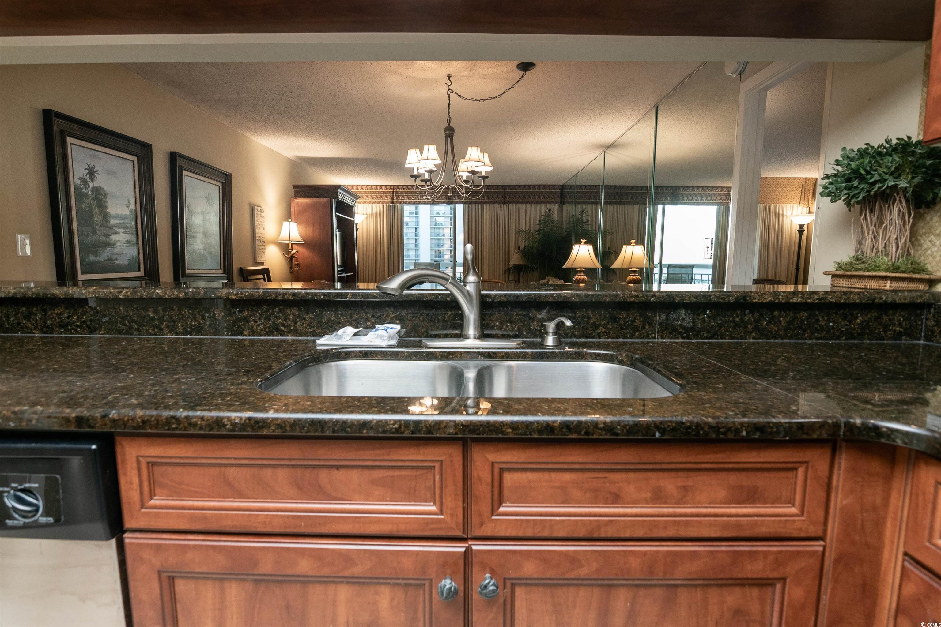 9820 Queensway Boulevard, Unit 1006 Myrtle Beach, SC 29572 - Photo 8 of 30 Kitchen featuring brown cabinetry, a textured ceiling, dishwasher, dark stone counters, and a chandelier