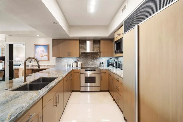 a kitchen with stainless steel appliances granite countertop a sink stove and cabinets