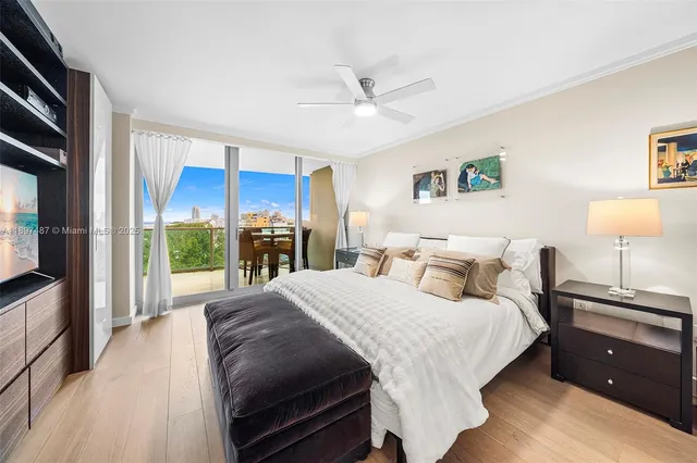 a bedroom with a large bed and a flat tv screen on dresser