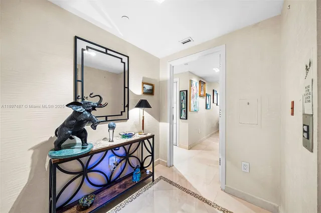 a view of a hallway to a livingroom with furniture and windows